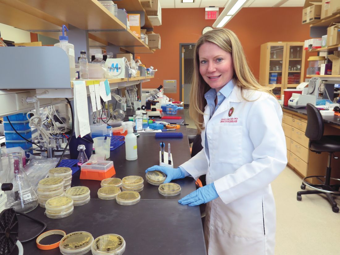 Dr. Jeniel Nett, of the University of Wisconsin, Madison, with C. auris shown on culture plates.