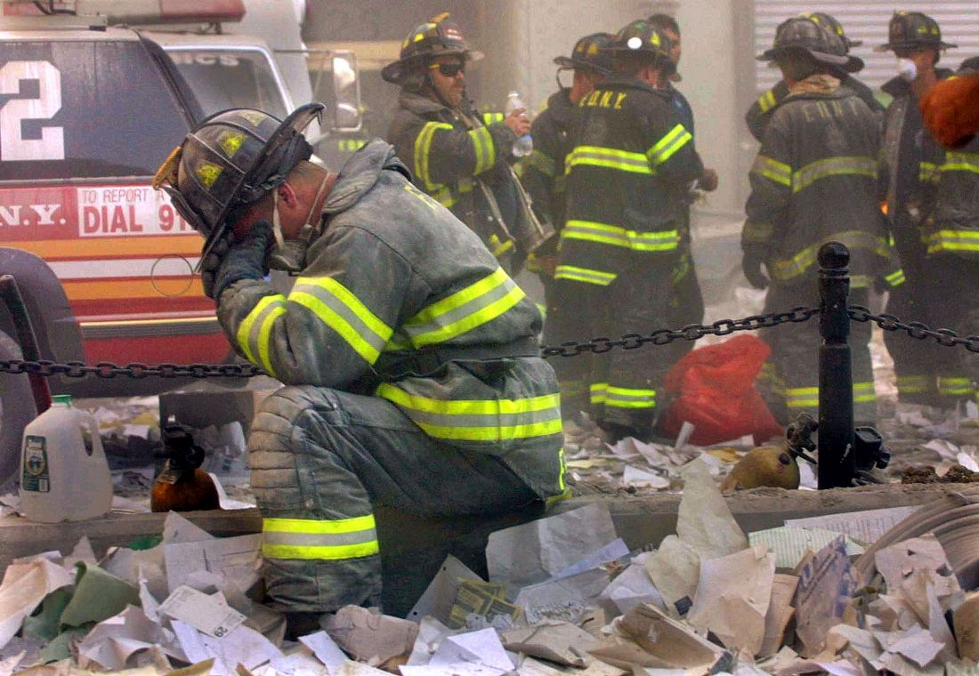 Firefighter Gerard McGibbon, of Engine 283 in Brownsville, Brooklyn, prays after the World Trade Center buildings collapsed September 11, 2001 after two hijacked airplanes slammed into the twin towers in a terrorist attack that killed some 3,000 people.