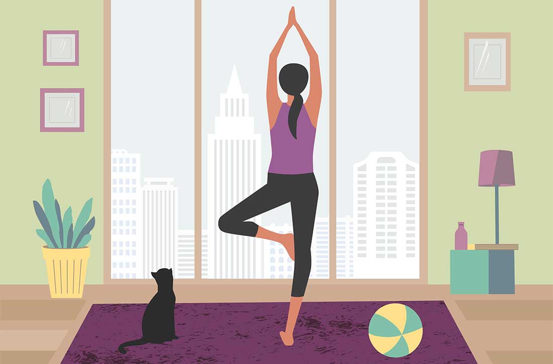 Woman standing in yoga pose next to cat