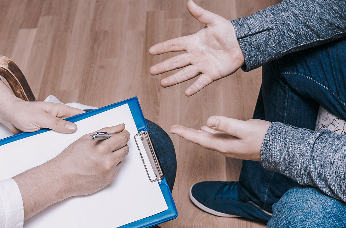 Psychiatrist holding clipboard with patient