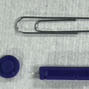 Paper clip and blood glucose testing lancet used for milia extraction.