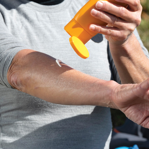 Man putting sunscreen on arm