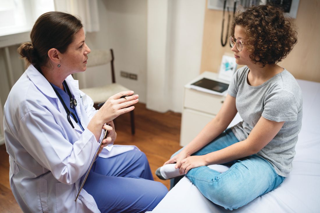 Doctor talking with teen girl.