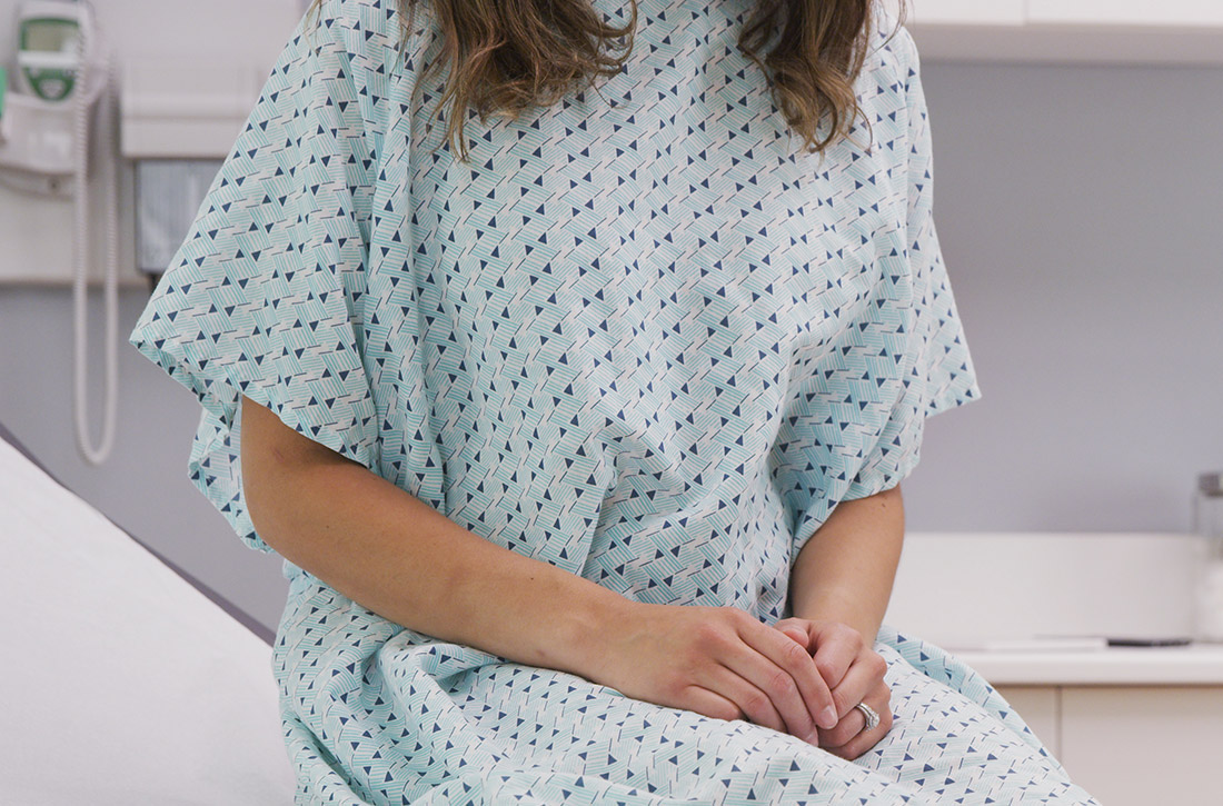 Woman sitting on table in doctor's office