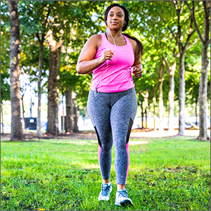 woman running outside in pink tank top and gray leggings