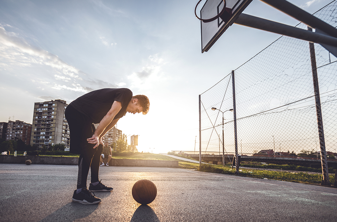 Man bent over on basketball court