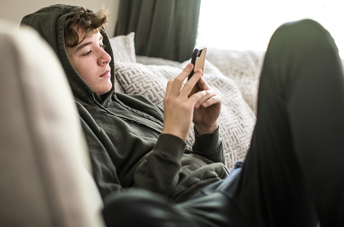 Boy on couch looking at cellphone