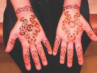 Red henna tattoo on the palmar surfaces of the hands.