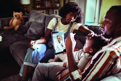 A young family consults with a doctor by using a digital tablet