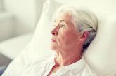 Older woman laying in bed staring off into the distance