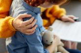 Child holding stuffed animal