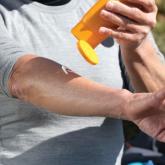 Man putting sunscreen on arm Man putting sunscreen on arm