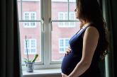 Pregnant woman looking out window