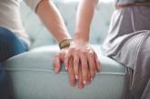 People holding hands on a couch