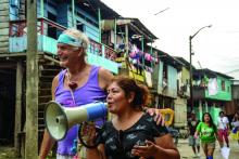 Dr. Carl A. Hammerschlag  receives assistance in announcing that the clowns are back in Belen, Peru, for their annual mental health clinics.