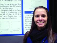 Dr. Yilien Alonso stands before her poster