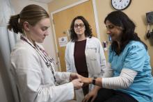 Dr. Lisa Criscione-Schreiber oversees rheumatology fellow Dr. Stephanie Giattino conducting a physical exam on a patient.