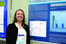 Dr. Julia Doss stands at her poster presentation.