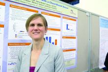 Dr. Kristin H. Gilchrist stands in front of her poster presentation.