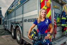 Dr. Deborah Feairheller, director of the HEART Lab and clinical associate professor of kinesiology at the University of New Hampshire, Durham, and a volunteer firefighter, stands by an emergency vehicle.
