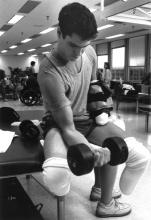 BJ Miller lifts weights in the gym during physical therapy.