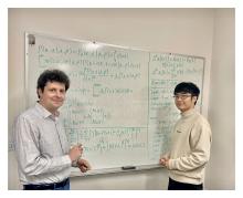 Paul Bogdan, PhD, (left) and research associate Chenzhong Yin are standing in front of a summary of their research.