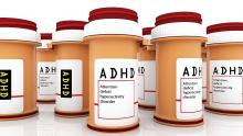 Opaque pill bottles with red lids and ADHD and attention deficit hyperactivity disorder written on them