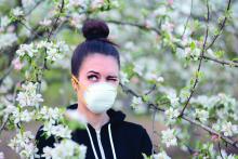 Young woman protecting herself with mask from pollen and allergens.