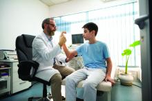 Doctor checks the condition of a boy's arm.