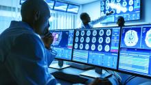 Over the shoulder shot of senior medical scientist working with CT brain scan images on a personal computer in laboratory.