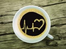 Coffee cup with ECG and heart drawn in foam