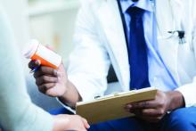 A doctor hands over prescription medication to a patient