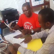 Ibrahim Bangura (red shirt) is the project's data manager. Idriss Kamara manages data for Sierra Leone's blood bank and transfusion services.