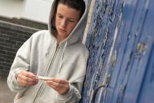 A youth rolls a cigarette