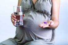 A pregnant woman takes pills