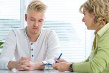 A doctor taking notes with a young male patient