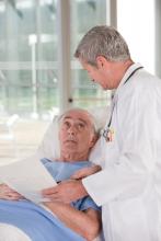 Elderly man in hospital bed consults with doctor