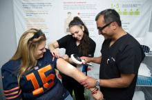 A dermatologist and his assistant examine a patient's skin, looking for potentially malignant lesions.