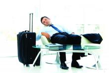 man asleep in airport terminal with luggage