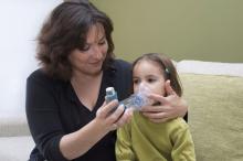 mother helping child with inhaler