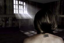 A woman imprisoned in a cell, with a barcode on her back, a victim of human trafficking