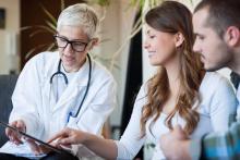 Doctor talking to pregnant patient.