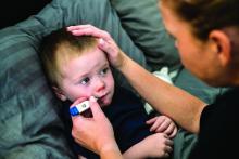 A mother caring for her 3-year-old son suffering from cold and flu symptoms.