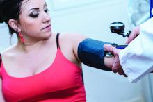 A young woman recieving a blood pressure measurement.