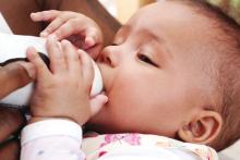 Baby drinking formula from a bottle.