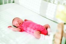 A newborn sleeping in a crib.