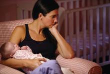 Woman with distressed expression holding a baby