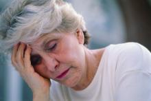 A woman rests her head in her hand.