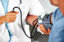 A health care provider monitors a patient's blood pressure.