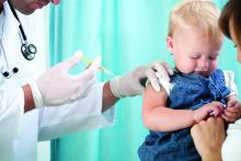 Toddler is held by mother while being vaccinated by doctor.